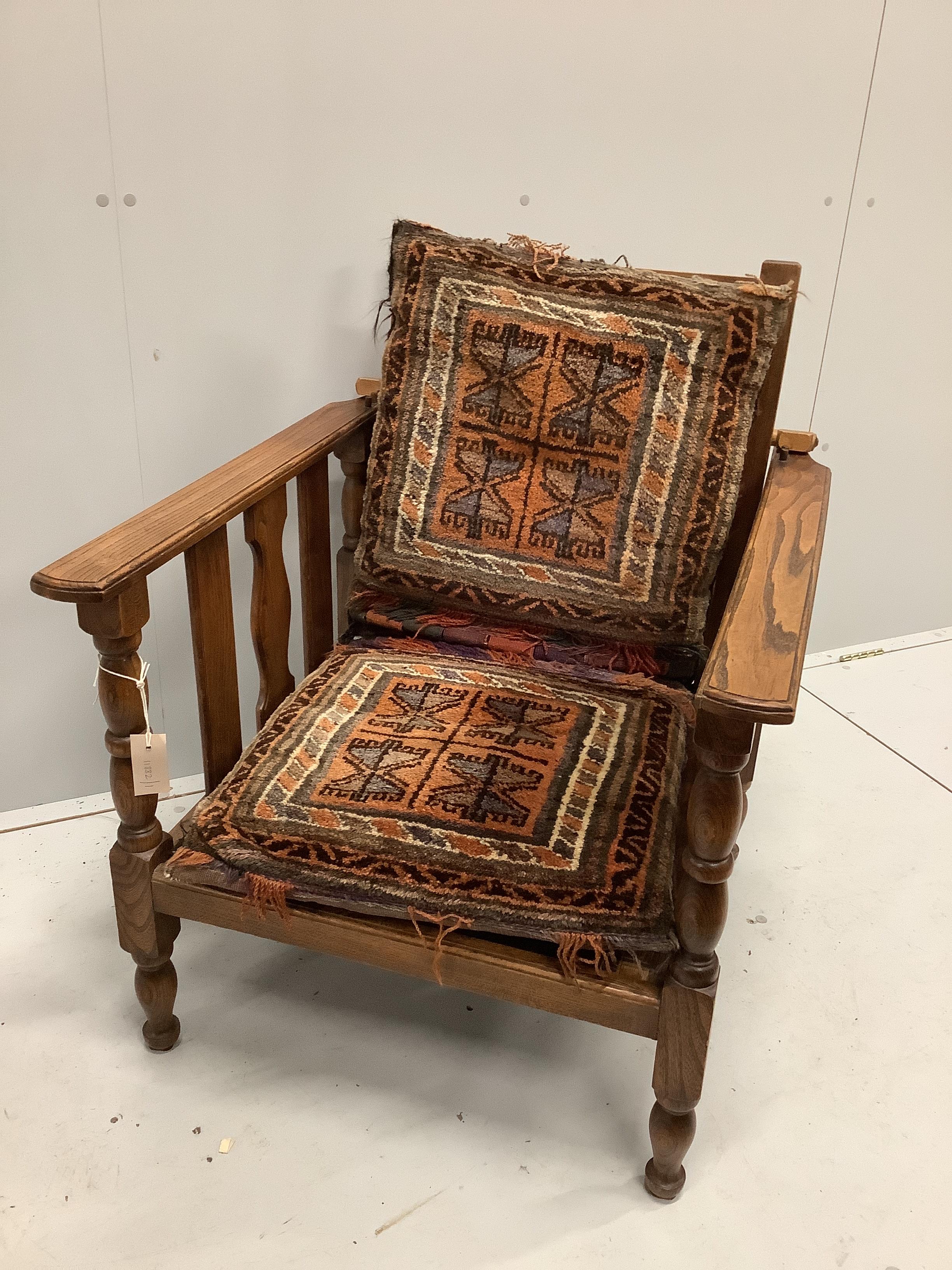 An early 20th century oak reclining elbow chair with Kilim seat and back, width 71cm, depth 78cm, height 84cm